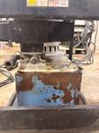 Pump valve block with quick-connect coupler above the blue oil reservoir