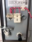 Inside of Square D enclosure door showing the data plate, contact block and red wiring
