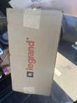 Cardboard shipping box printed with the red Legrand logo, held by hand