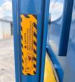 Yellow caution label on the blue frame about cylinder binding and clevis clearance