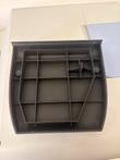 Underside of a removed gray plastic access cover showing internal ribbing