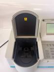 Sample compartment lid open on the Beckman spectrophotometer, showing the black cell holder