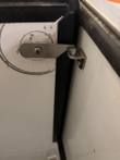 Stainless latch arm and catch bracket on the inside frame of the milk cooler