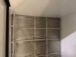 White coated wire shelf racks inside the milk cooler cabinet