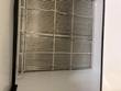 White coated wire shelf racks and white floor inside the milk cooler cabinet