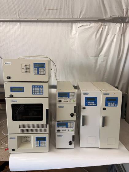 Full Jasco HPLC set on a white table: stacked detector and sampler, two pumps and two column ovens