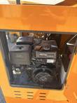 Open engine bay of the orange crusher showing a 457cc OHV gas engine and black fuel tank