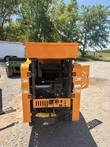 Rear of the orange tracked crusher with top hopper, control panel and engine visible, side door open