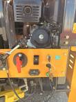Crusher control panel with red battery disconnect handle, switches, hour meter and keys, engine behind
