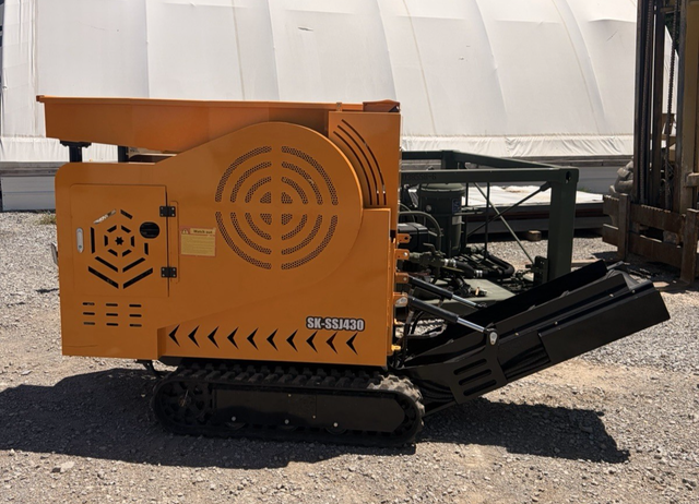 Orange SK-SSJ430 mini tracked jaw crusher from the side with rubber tracks, top hopper and black discharge conveyor