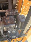Gas engine with a black fuel tank and air cleaner inside the crusher's open side door