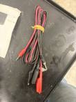 Pair of black and red test leads with alligator clips, bundled with a rubber band
