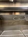 Evaporator fan housing at the top of the refrigerator interior, above the top wire shelf