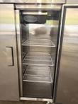 Inside the left refrigerator compartment: three white wire shelves, fan housing at the top, right door open