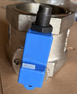 Tight view of a butterfly valve's blue handle cover and threaded port