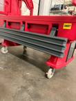 Gray bumper rail along the side of the red carrier, caster wheels and a yellow 3887 tag