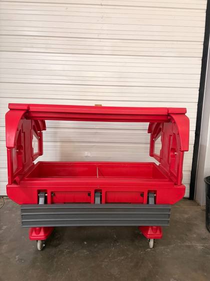 Red insulated carrier on casters with both end doors swung open, well and gray bumper rail visible