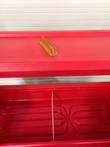 Inside the red carrier: ribbed well floor with a divider, amber sign holder on the lid above