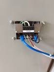 Terminal block labeled 115VAC with green, white and black wires and a blue Ethernet cable behind the door