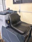 Black operator seat with seat-belt retractors on a Nilfisk Liberty SC60 scrubber, solution tank behind