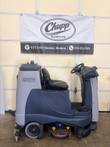 Nilfisk Liberty SC60 ride-on floor scrubber, side view, gray tank, black seat, steering wheel and scrub deck