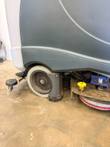 Nilfisk Liberty SC60 drive wheel, squeegee arm and pink disc scrub brush beneath the body