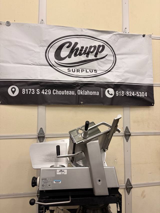Bizerba SE 12 D slicer on a black cart with carriage tilted up, Univex service sticker on the housing