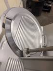 Round slicing blade with ribbed face and blade guard ring on the Bizerba SE 12 D, tray edge in front
