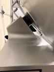 Side close-up of the Bizerba slicer blade ring and gray gauge plate, light scratches on the metal housing