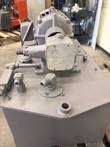 Hydraulic pump with worn data plate and JIC fittings on the gray steel reservoir top, motor behind