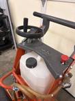 Floor saw control deck: handwheel, handle, red emergency stop button, white water tank and brass water valve