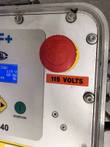 Red emergency stop button and 115 volts label on the MSA 340 panel, beside the start/ok button and display edge